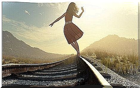 Woman walking on railway tracks