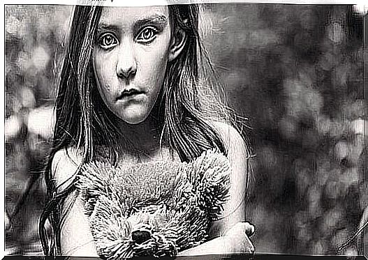 Sad girl holding a teddy bear