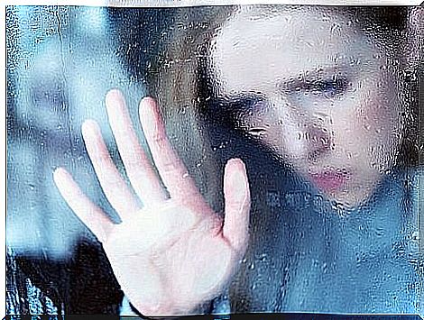 Sad woman looks out the window, confronts pain