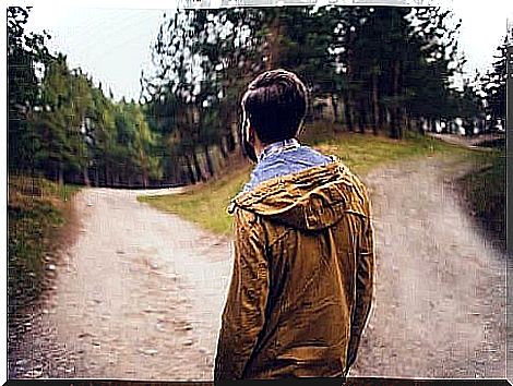 A man in front of two roads representing different decisions.