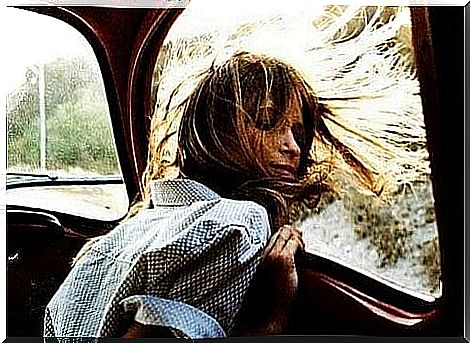 Happy woman looking out car window