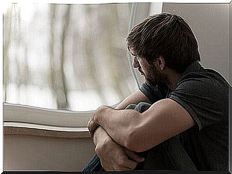 Man looks out the window and tries to forget