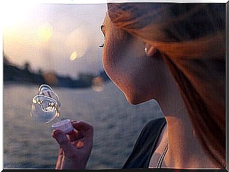 Woman blowing bubbles by the sea