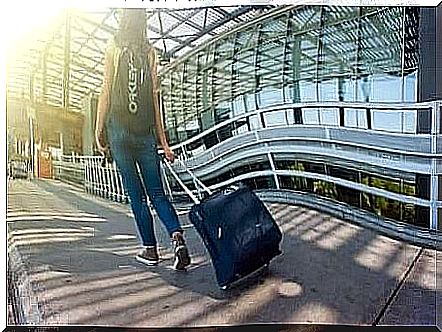 A woman pulling on a suitcase.