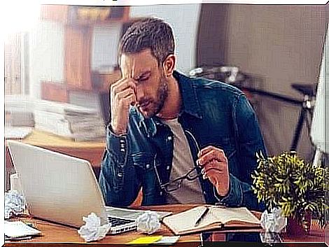 A man sitting at a laptop and stressed