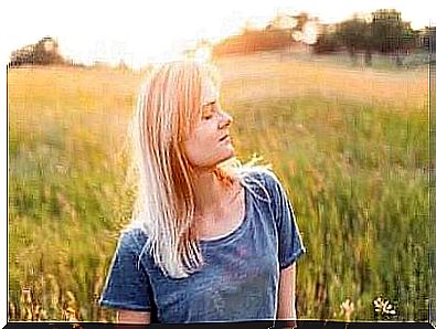 Woman with closed eyes standing in a meadow