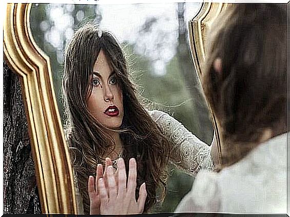 A woman looks at a mirror thinking about being responsible for her actions.