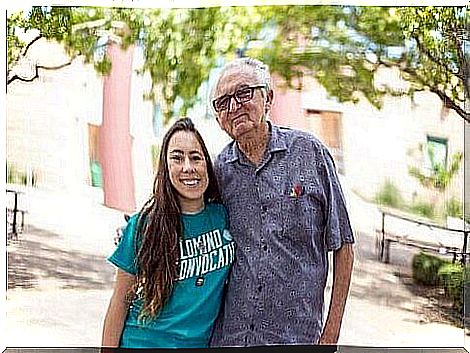 An old man hugging a younger woman.