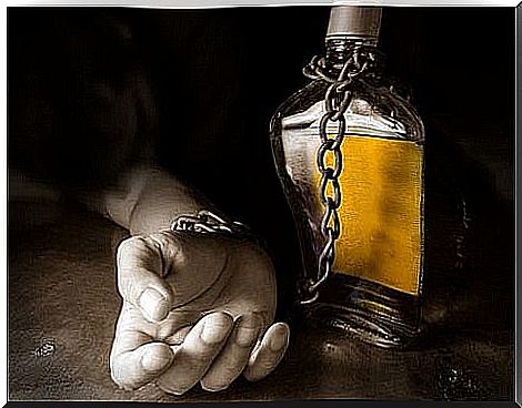 Hand chained to bottle of alcohol