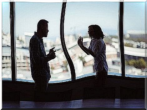 Two arguing in front of a window