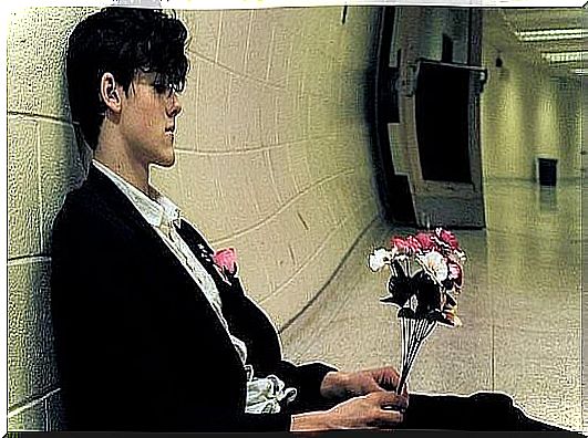 boy sitting in the hallway with flowers symbolizing leaving your partner but could not