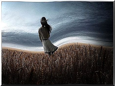 A girl in a wheat field thinking of possibilities